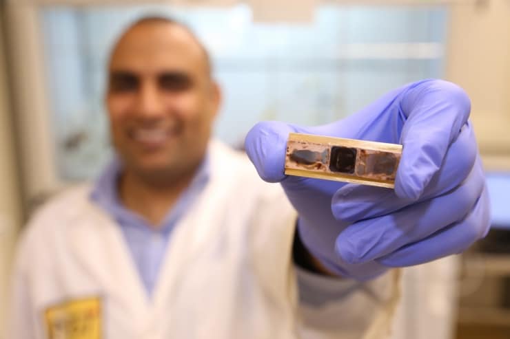 Research scientist Virendra Singh, from the George W. Woodruff School of Mechanical Engineering at Georgia Tech, holds a test sample used to measure thermal conductance and thermal cycle reliability in a new polymer material developed to remove heat from electronic devices. (Georgia Tech Photo: Candler Hobbs)
